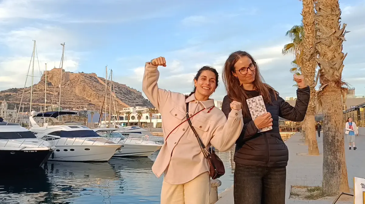 Two people holding the project card at a marina